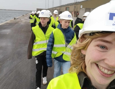 Skoleklasse på besøg hos Port of Aalborg. På billedet ses eleverne gå langs kajen i gule sikkerhedsveste og hvide beskyttelseshjelme